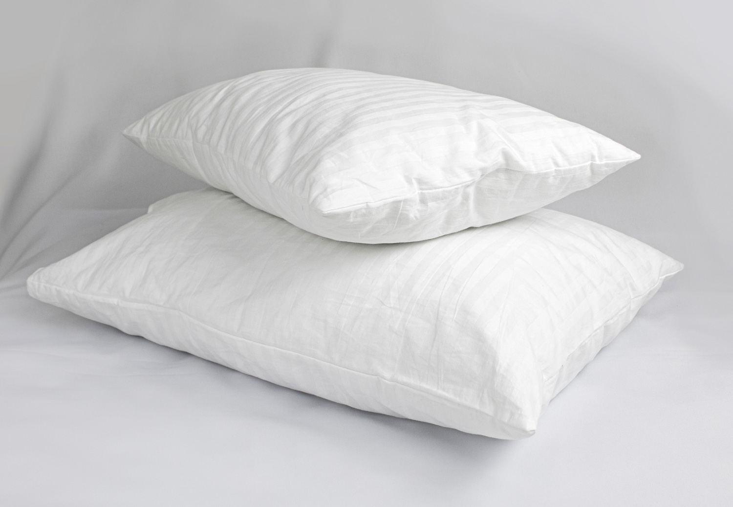 Two white pillows in striped cotton pillowcases.