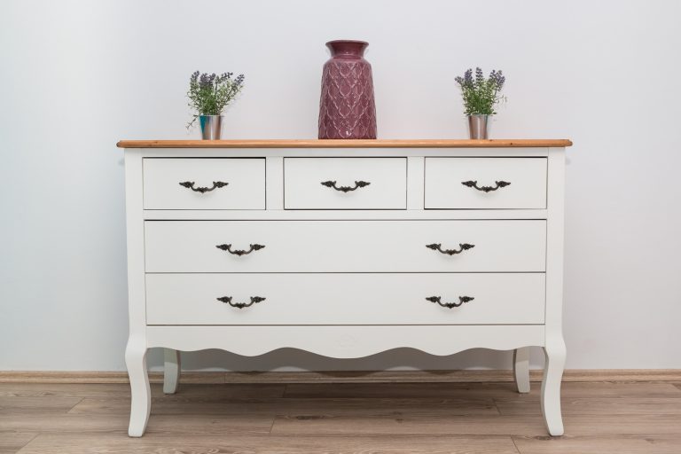 White wooden dresser with three vases and flowers on white wall background. - How To Paint An IKEA MALM Dresser