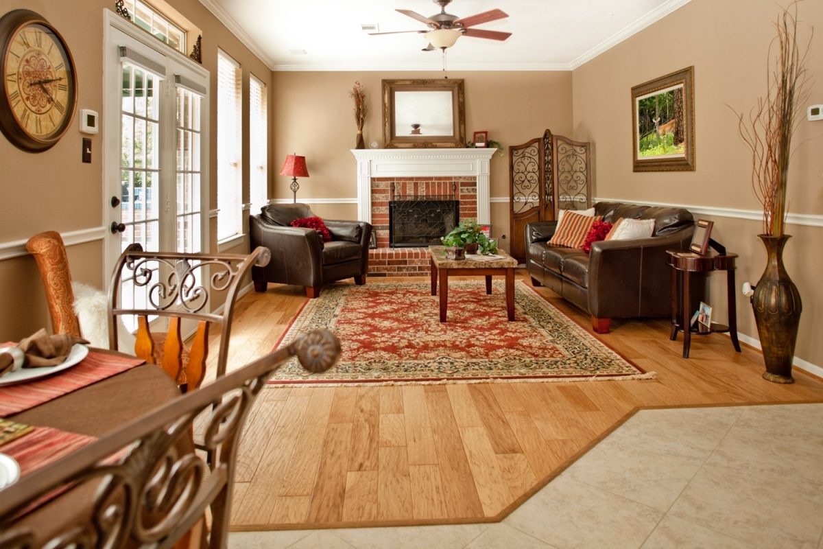 lovely showcase living room with tan and red color scheme with matching fan and floor