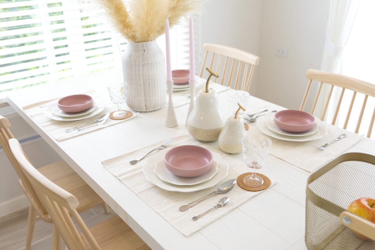 white and purple plate setting on dinning table at home.

